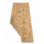 Wooden map of Alberta with engraved text and symbols on a white background