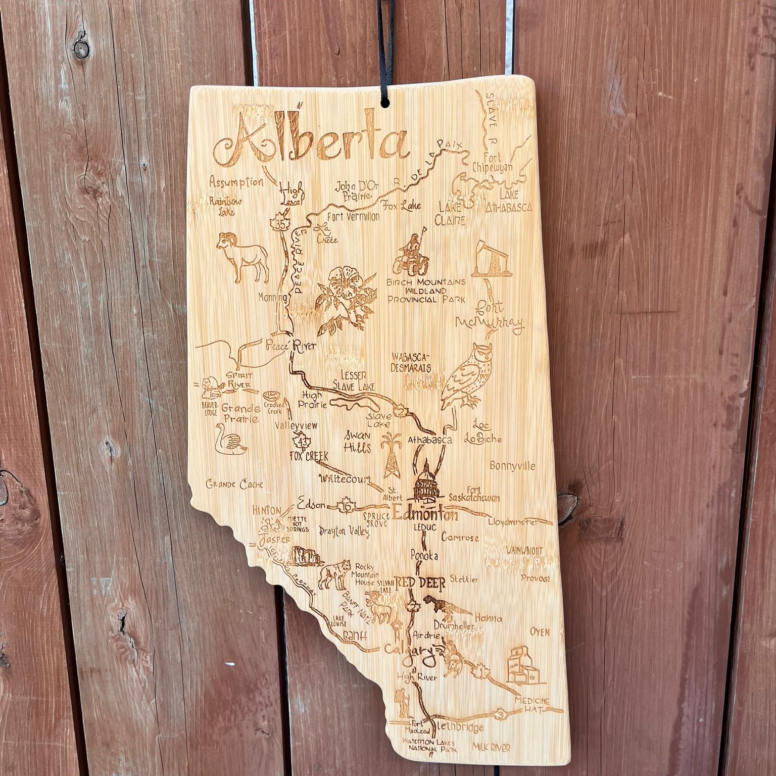 Wooden map of Alberta with engraved details on a wooden background